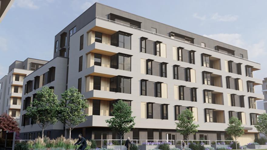 Digital render of Village on the Green housing project. There is a large, square housing building behind a fence.